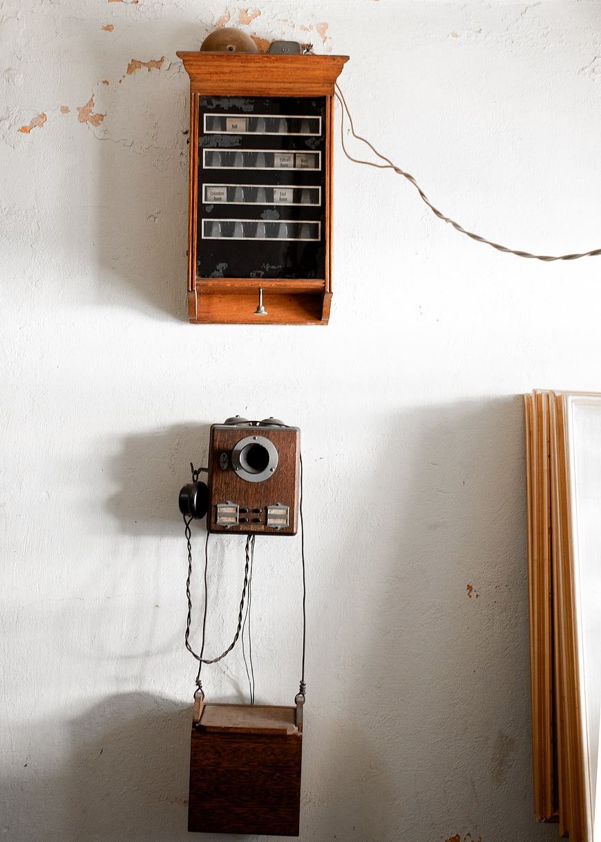 Vintage Wall Telephone and Telegraph Equipment on White Wall