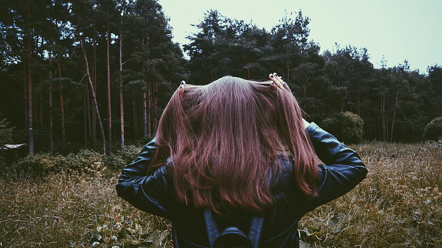 Woman with Pink Hair in Leather Jacket Facing Forest