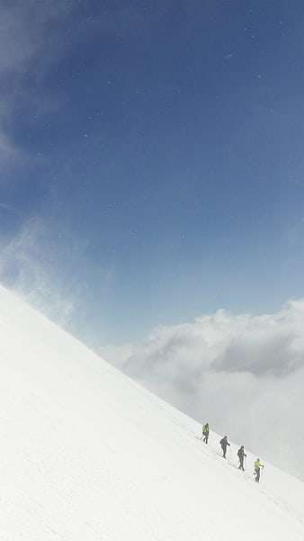Group of hikers ascending snowy mountain slope
