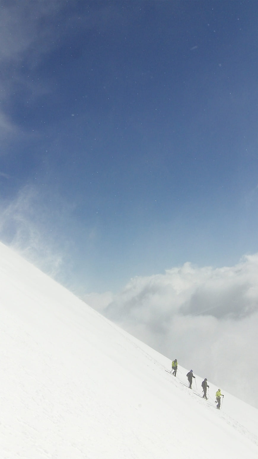 Group of hikers ascending snowy mountain slope