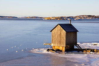 Wooden sauna cabin on frozen sea ice in winter
