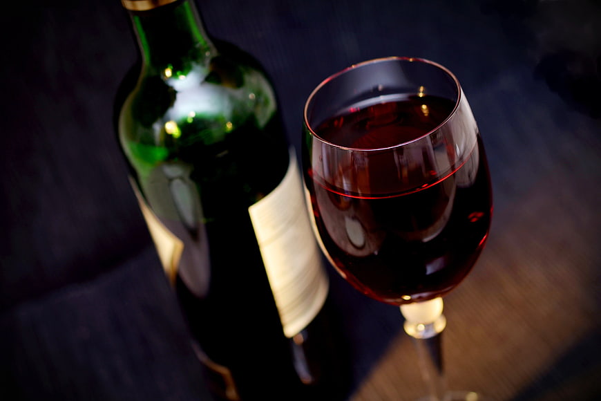 Bottle and Glass of Red Wine on Dark Table