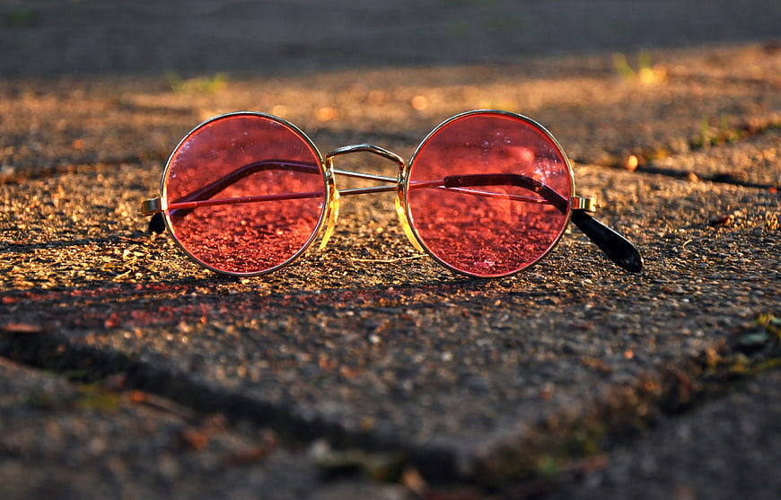 Round Red Tinted Glasses On Textured Concrete Surface