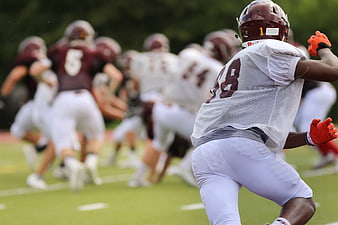 American football player running during practice on field