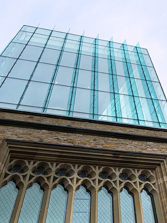 Modern glass architecture atop historic stone building facade
