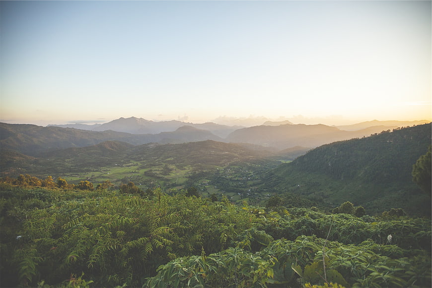 Serene Mountain Valley Landscape at Sunrise with Green Hills