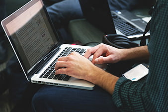 Close-up of hands typing on a laptop keyboard