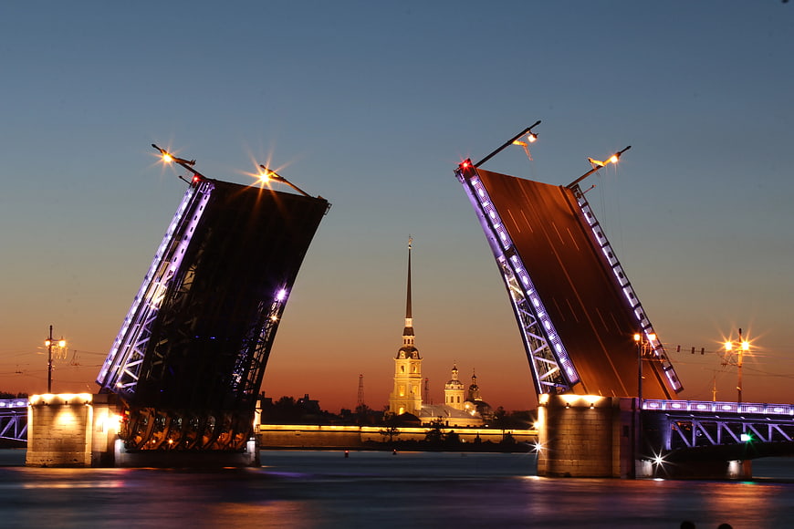 Drawbridge opening at twilight with illuminated cathedral in background