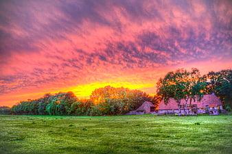 Vibrant pink and orange sunset over rural farm landscape