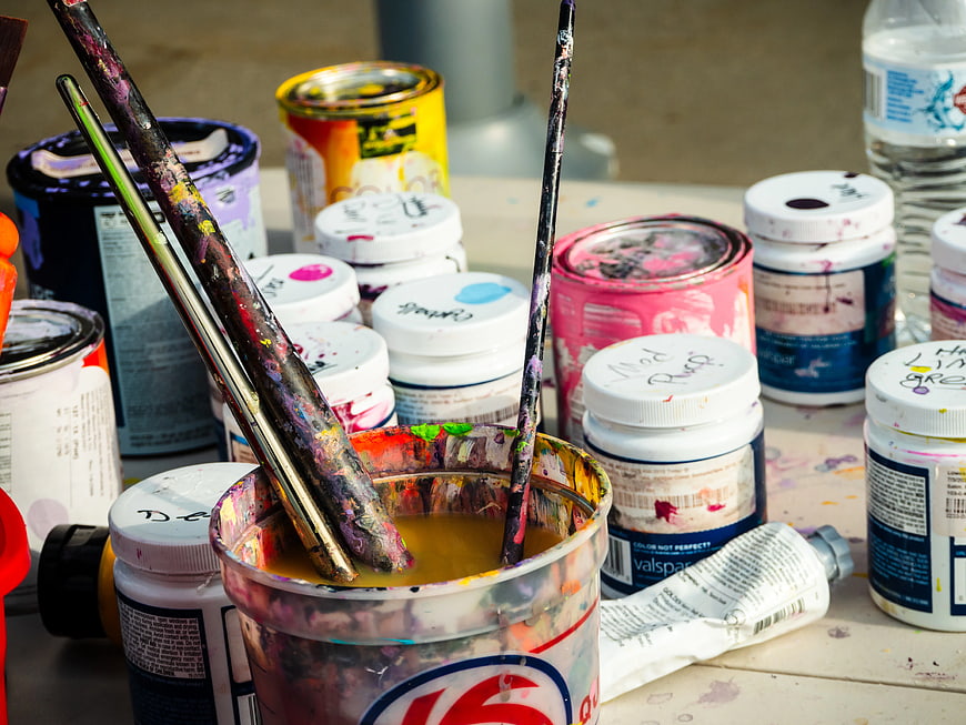 Used Paint Brushes and Cans on Art Table