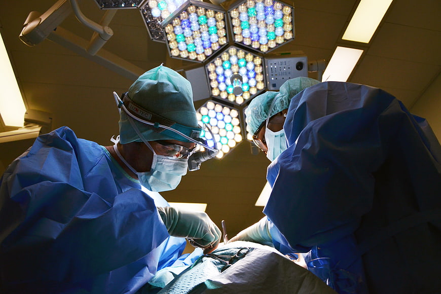 Surgeons performing surgery under bright operating lights