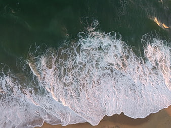 Aerial View of Ocean Waves Crashing on Sandy Beach