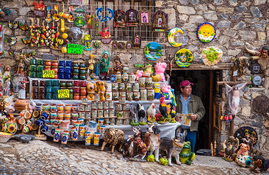 Man Reading Newspaper At Colorful Mexican Souvenir Market Stall