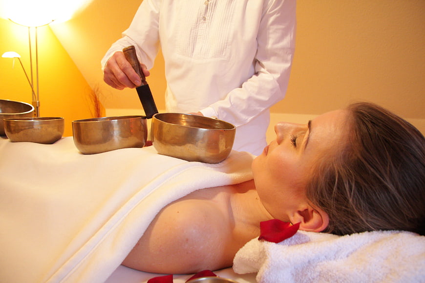 Woman receiving singing bowl sound therapy massage