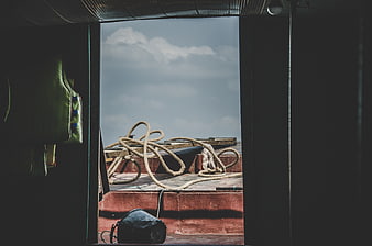 View from boat cabin doorway to deck with rope and sky