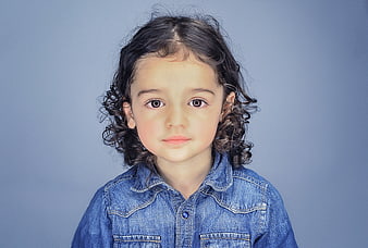 Studio Portrait of Young Girl with Curly Hair in Denim Shirt