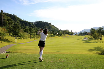 Woman Playing Golf On A Scenic Green Course