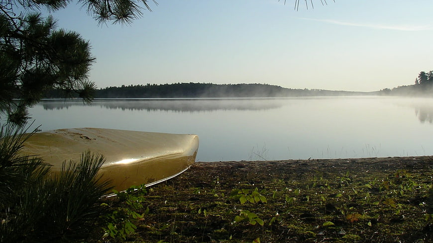 Yellow Canoe on Misty Lake Shore Morning