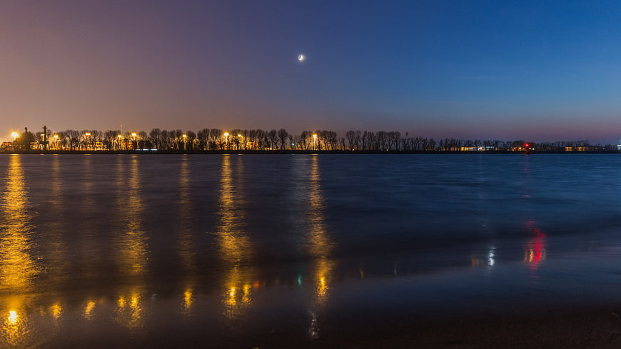 Serene Night River Landscape with Moon and City Lights Reflection