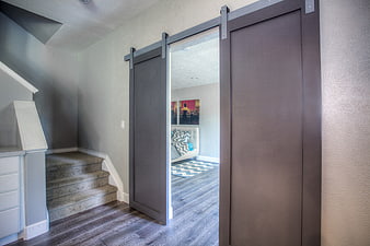 Modern Interior with Dark Grey Sliding Barn Doors and Staircase