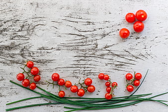 Fresh cherry tomatoes and chives on rustic white wood