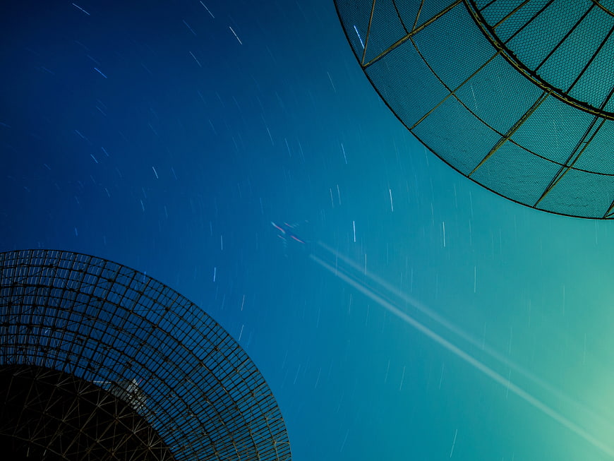 Star Trails Above Radio Telescope Dishes at Night