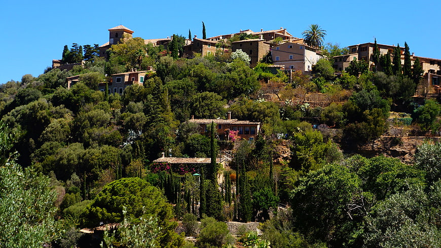 Sunny Mediterranean hillside village with lush greenery