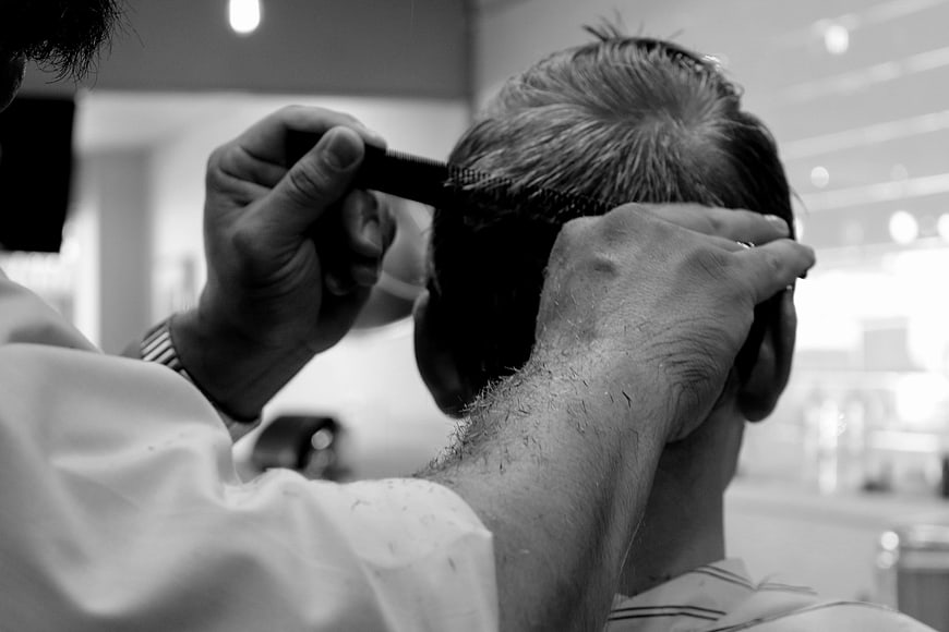 Barber Cutting Hair with Comb in Black and White
