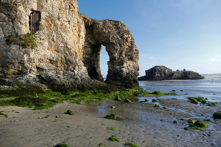 Natural Rock Arch on Sandy Beach at Low Tide