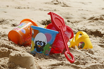 Colorful Plastic Beach Toys and Buckets in Sand