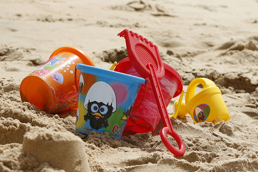 Colorful Plastic Beach Toys and Buckets in Sand