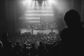 Black and white concert crowd with American flag backdrop