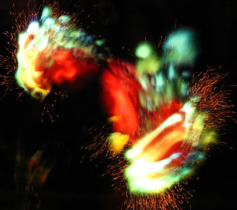 Abstract multicolor light trails and sparks on black background