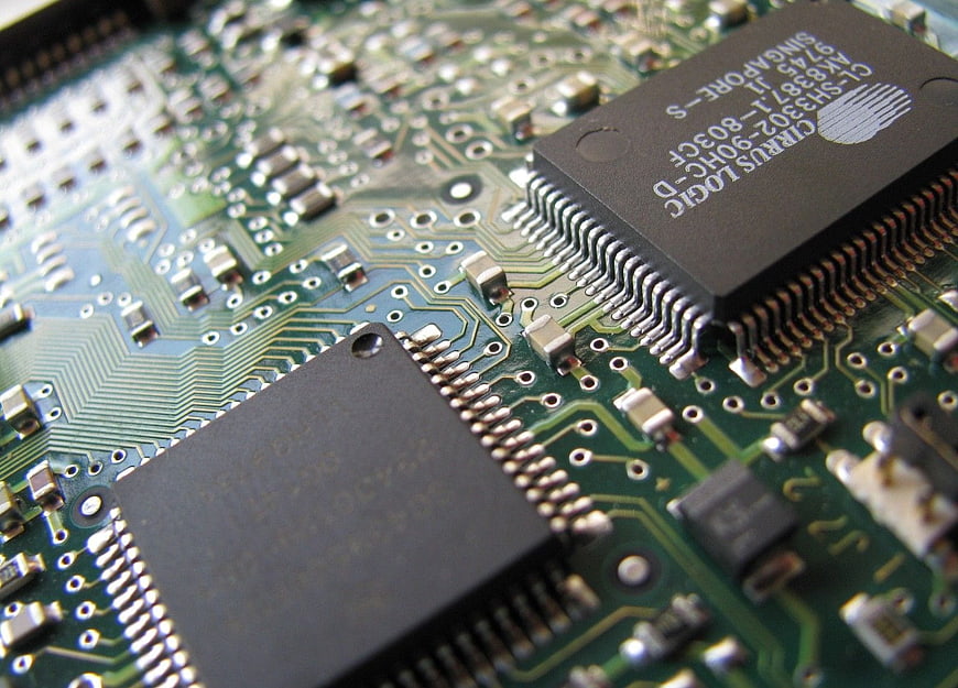 Close-up of green circuit board with microchips and electronic components