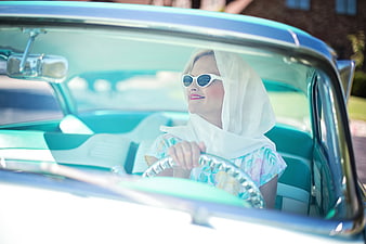 Retro woman driving vintage turquoise classic car