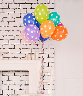 Colorful Polka Dot Balloon Bouquet Against White Brick Wall