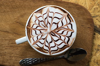 Top View of Cappuccino with Intricate Latte Art on Wooden Board