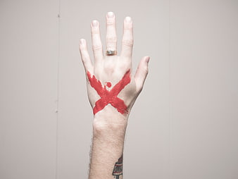 Hand with Red Paint X Mark and Gold Ring