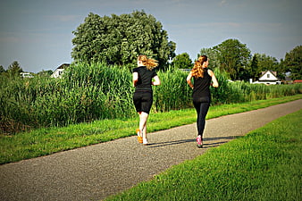 Two Women Jogging on a Path in Nature