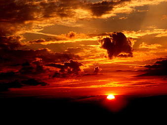 Dramatic fiery sunset with orange clouds and sun