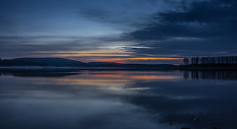 Serene Lake Sunset with Orange Horizon and Blue Sky Reflection