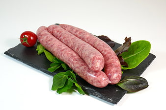 Raw Sausages on Black Slate with Fresh Herbs and Cherry Tomato