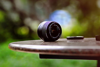 Camera lens on wooden table outdoors