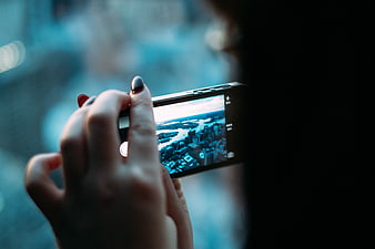 Woman taking photo of city skyline with smartphone