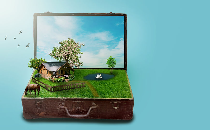 Surreal miniature idyllic farm landscape inside an open vintage suitcase