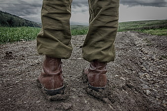 Close-up of military boots and trousers on a gravel path