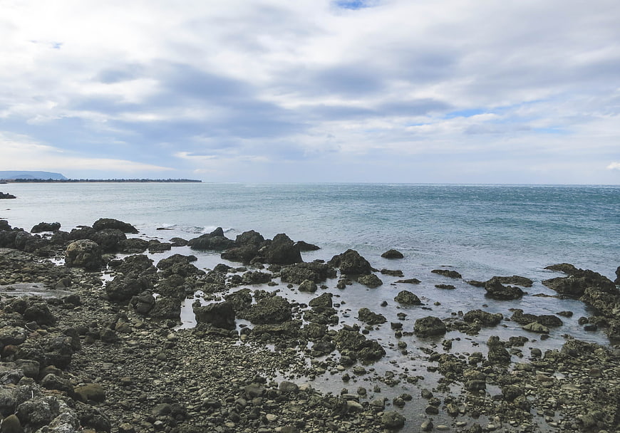 Rugged Rocky Coastline with Calm Ocean and Cloudy Sky