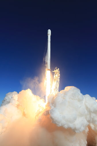 SpaceX Falcon 9 rocket launch with bright exhaust plume and smoke