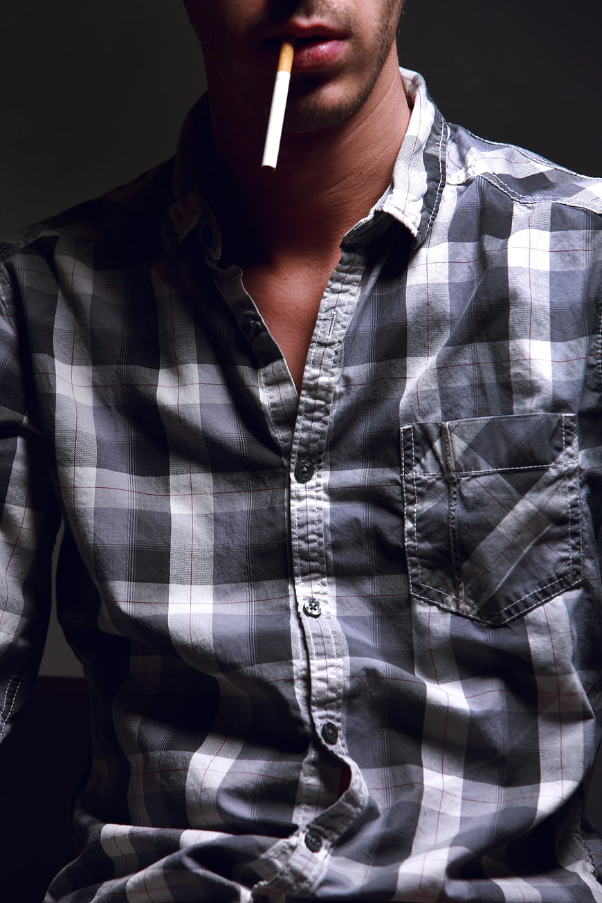 Man smoking cigarette in plaid shirt close-up