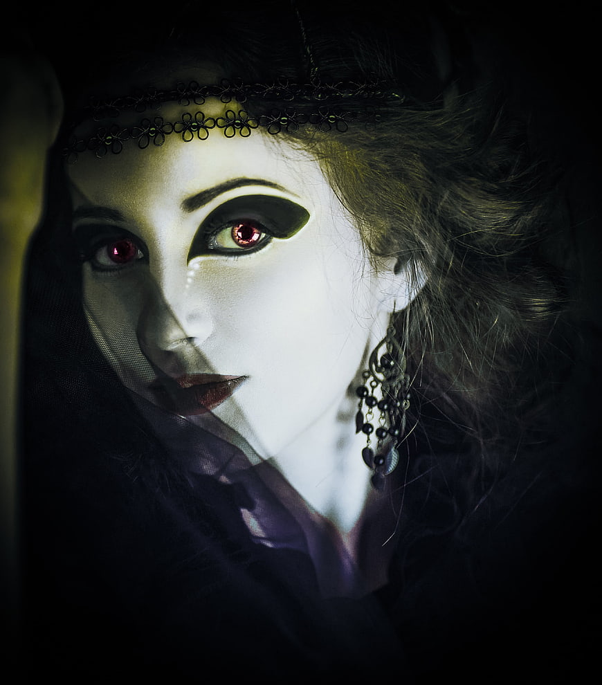 Gothic woman with pale makeup and red eyes in dark fantasy style